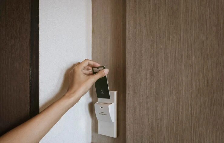 Sett nøkkelkortet for hånd inn i holderen på hotellromsveggen for å åpne hovedbryterlåsen.