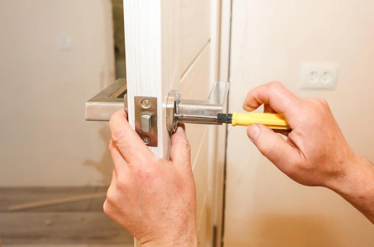 Låsesmed installerer reparasjon av dørhåndtak